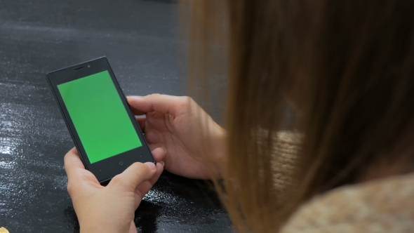 Woman Looking At Smartphone With Green Screen
