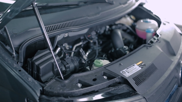 An Employee Checks The Oil In a The Client Car. alt