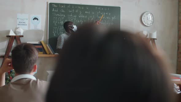 Afro-American Student in Mask Taking by Chalkboard on Lesson alt