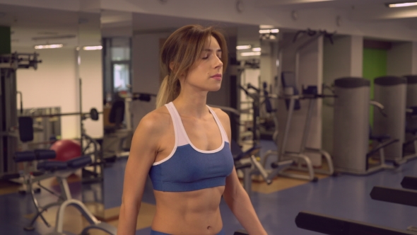 Beautiful Girl Trains On Treadmill In Gym Alone.