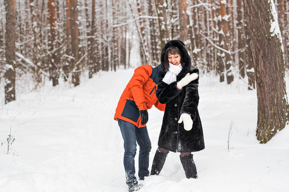 Young couple playing in snow, having snowball fight - Stock Photo - Images