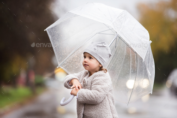 Little Girl Under The Transparent Umbrella Outside Rainy Day