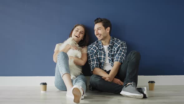 Zoom out video of couple with dog in empty house. Shot with RED helium camera in 8K alt