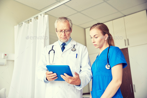 senior doctor and nurse with tablet pc at hospital - Stock Photo - Images