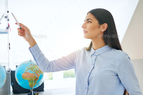 Calm Indian woman pointing with marker at board