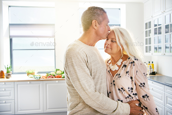 Handsome man kissing wife on forehead