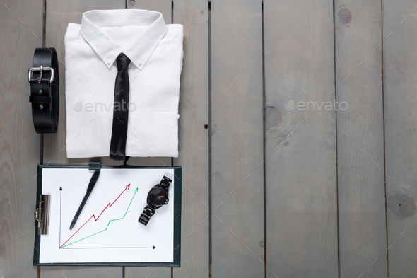 Businessman, work outfit on grey wooden background. White shirt with black tie, watch,