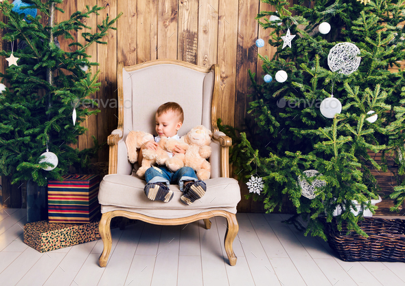 Happy little boy playing near the Christmas tree - Stock Photo - Images