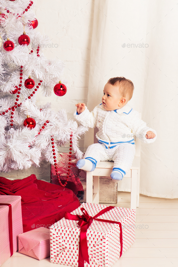 Portrait of a little boy at home near the Christmas tree. - Stock Photo - Images