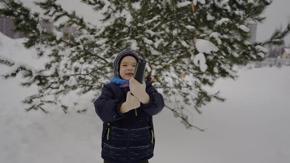 A Boy Exploding Firecracker Confetti on the Street Near the Christmas Tree