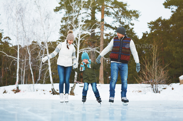 Cheerful family skating in park - Stock Photo - Images