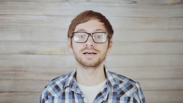 Young Man In Glasses Talking To Camera