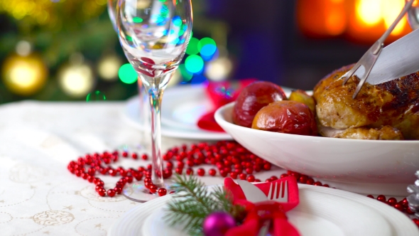 Roasted Chicken On Christmas Table In Front Of Fireplace And Tree With Lights