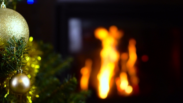 Decorated Christmas Tree With Lights In Front Of Fireplace