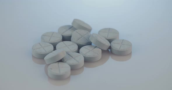 Prescription drugs - Capsules, pills, tablets on reflective background alt