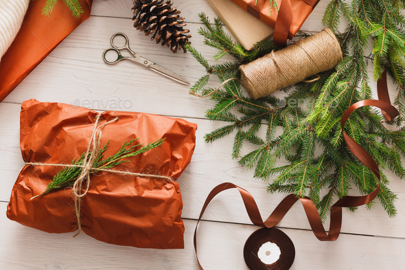 Wrapping christmas present gift on white wood background - Stock Photo - Images
