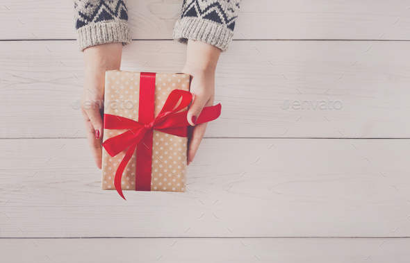 Woman's hands give christmas gift in present box - Stock Photo - Images