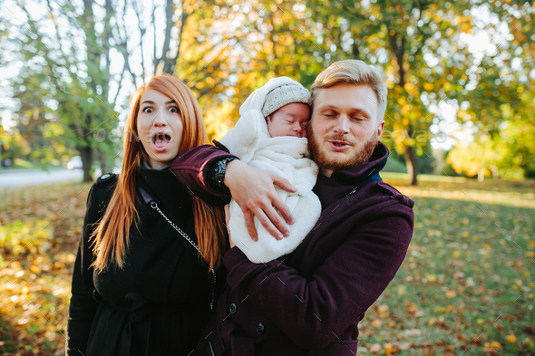 young family and newborn son in autumn park - Stock Photo - Images