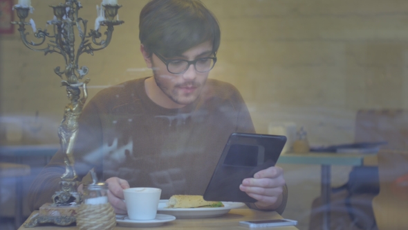 Man Using a Tablet In The Cafe