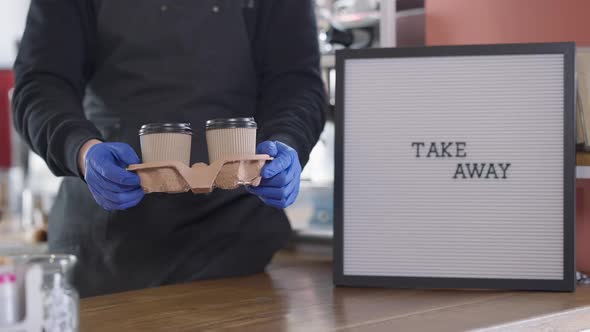 Unrecognizable Man in Gloves Stretching Take Away Coffee Cups to Camera alt