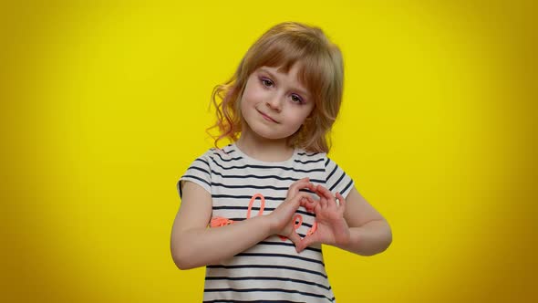 Smiling Child Girl Makes Heart Gesture Demonstrates Love Sign Expresses Good Feelings and Sympathy alt