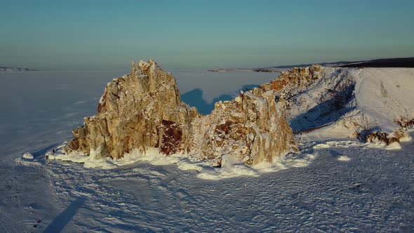 Aerial flight around sacred Shaman rock at sunset in winter alt