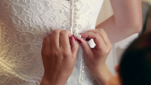 Getting Ready For Wedding Ceremony. Mother Or Bridesmaid Helping Young Bride To Dress Up Bridal