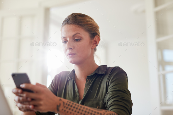 Beautiful young woman using mobile phone at home - Stock Photo - Images