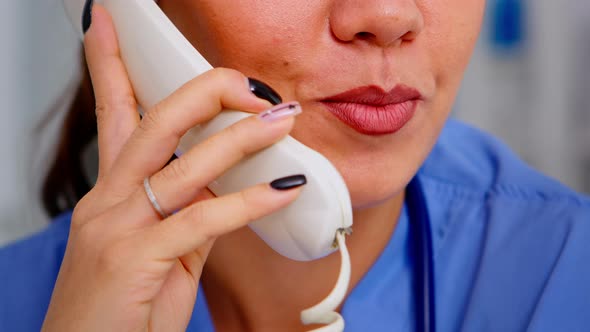Close Up of Specialist Practitioner Talking at Phone During Telehealth alt