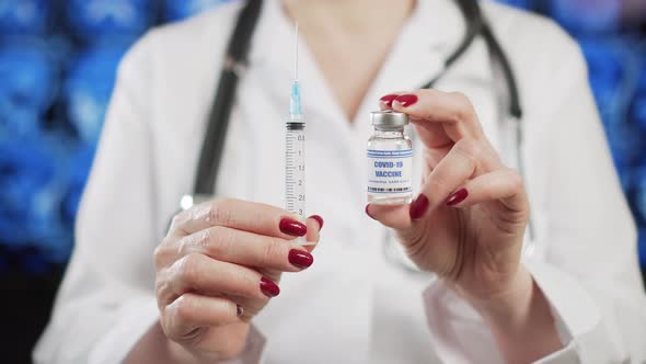 Doctor shows ampoule with COVID-19 vaccine and syringe. Coronavirus vaccination	 alt