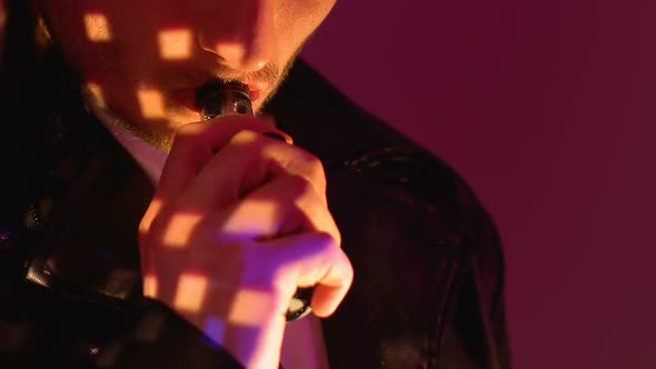Drunk Man Smoking Electronic Cigarette, Relaxing at Night Club Party, Close-Up alt