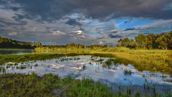 Cloudy sky over beautiful flood plain landscape - Stock Photo - Images