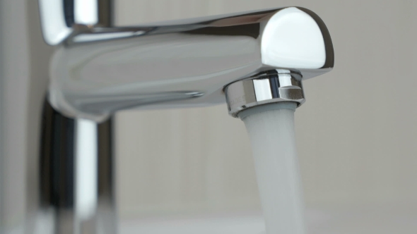 Strong Water Pressure Flowing From a Chrome Tap