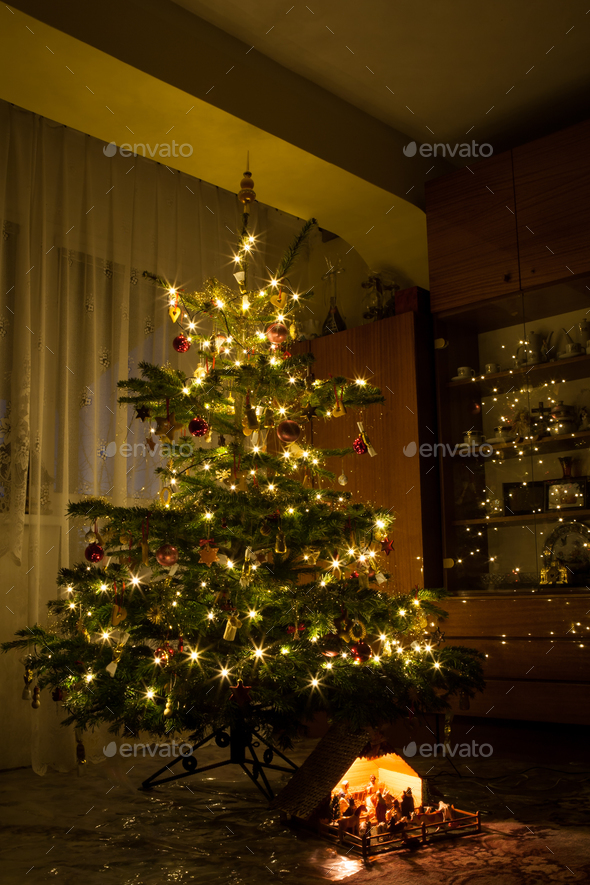 Nativity scene decoration under lighted Christmas tree Stock Photo by ...