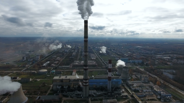 Ecology Pollution. Industrial Factory Pollutes The Environment Blowing Smoke From Pipes. alt