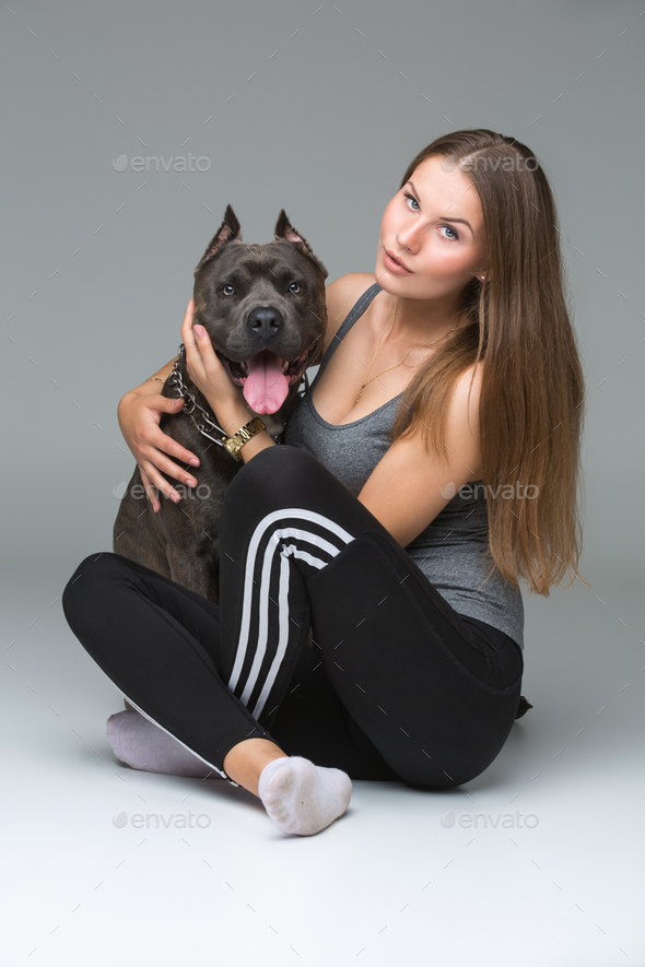 Beautiful girl with grey stafford terrier - Stock Photo - Images