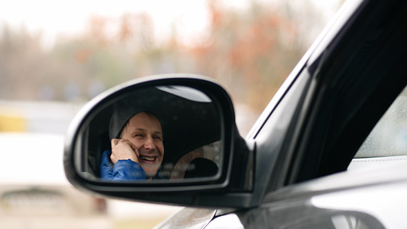 Male Sitting in a Car and Talking on Mobile Phone, Shot With Mirror Car