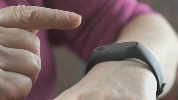 The Elderly Woman Using the Smart Fitness Tracker