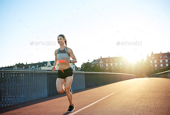Athletic young woman enjoying a morning run - Stock Photo - Images