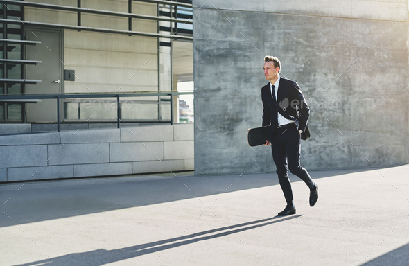 Young businessman with skateboard walking in rush