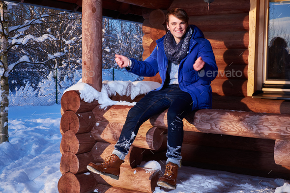 Young man spend winter holidays at mountain cottage