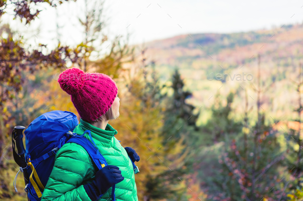 Hiking woman with backpack looking at inspirational autumn golde - Stock Photo - Images