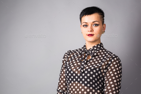 Portrait of business woman or creative professional. Grey background, with  copy space. Stock Photo by Satura_