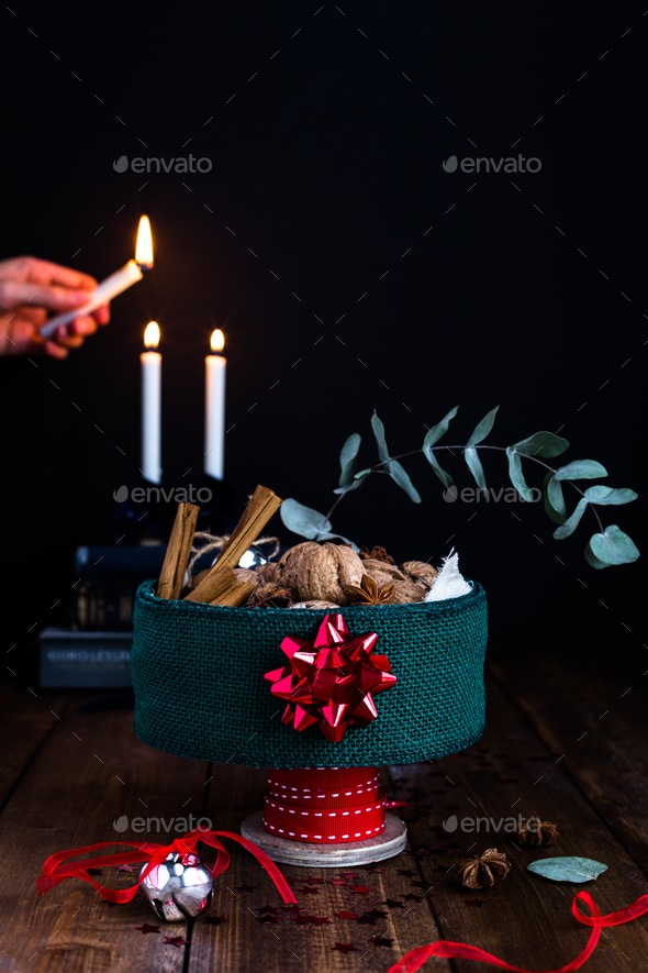 Festive Tin Filled with Nuts on Rustic Table against Candlelit Background - Stock Photo - Images