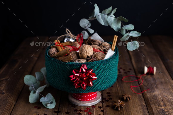 Horizontal View of Christmas Tin filled with Nuts and Spices on Rustic Table - Stock Photo - Images