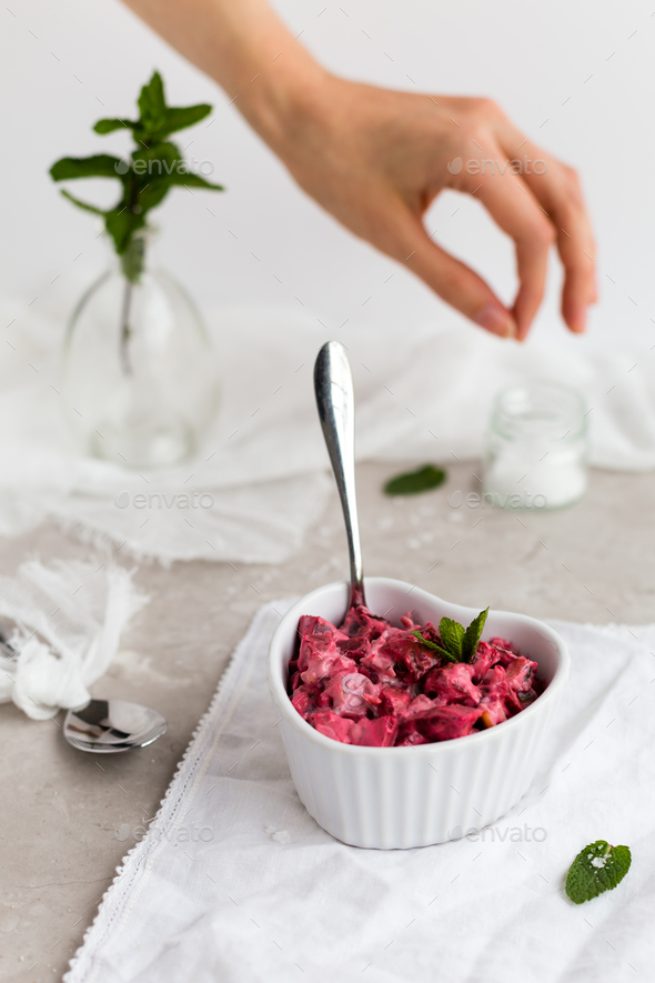 Beetroot Dip in White Dish with Female Hand Seasoning in Background - Stock Photo - Images