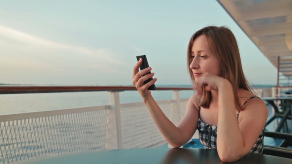Woman Using Mobile Phone on Cruise Ship