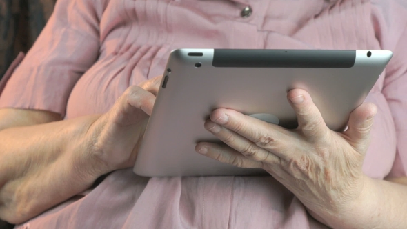 The Old Woman Holding the Silver Tablet Computer