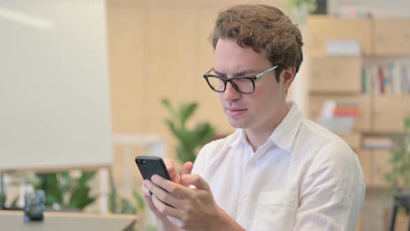 Portrait of Young Man Having Loss While Using Smartphone alt