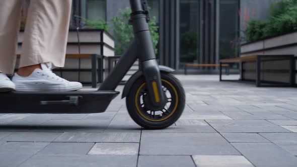Closeup Woman Legs Riding Scooter Stop at City Center to Rest alt